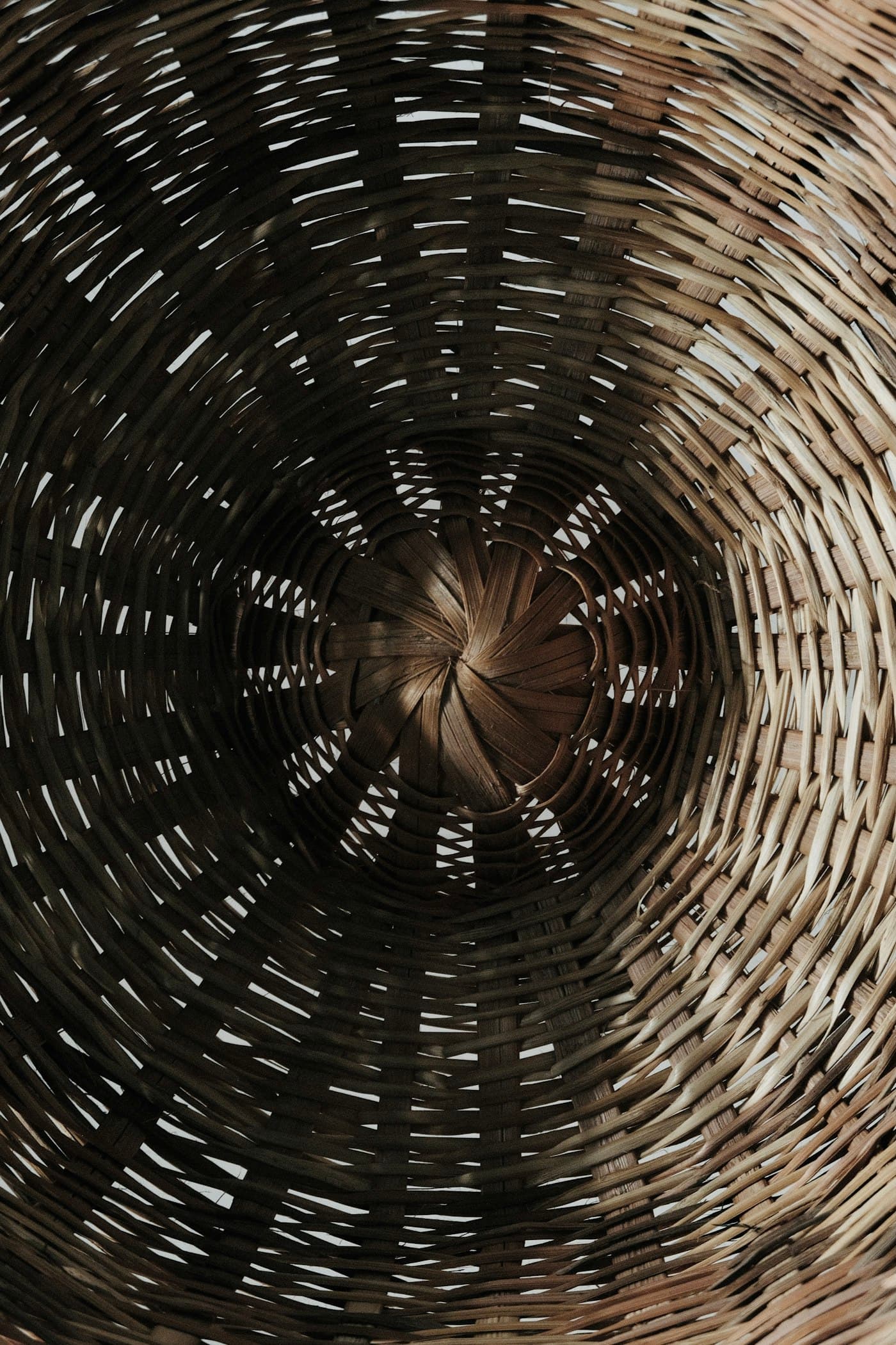 Close view of the spiralling woven base of a shallow basket.