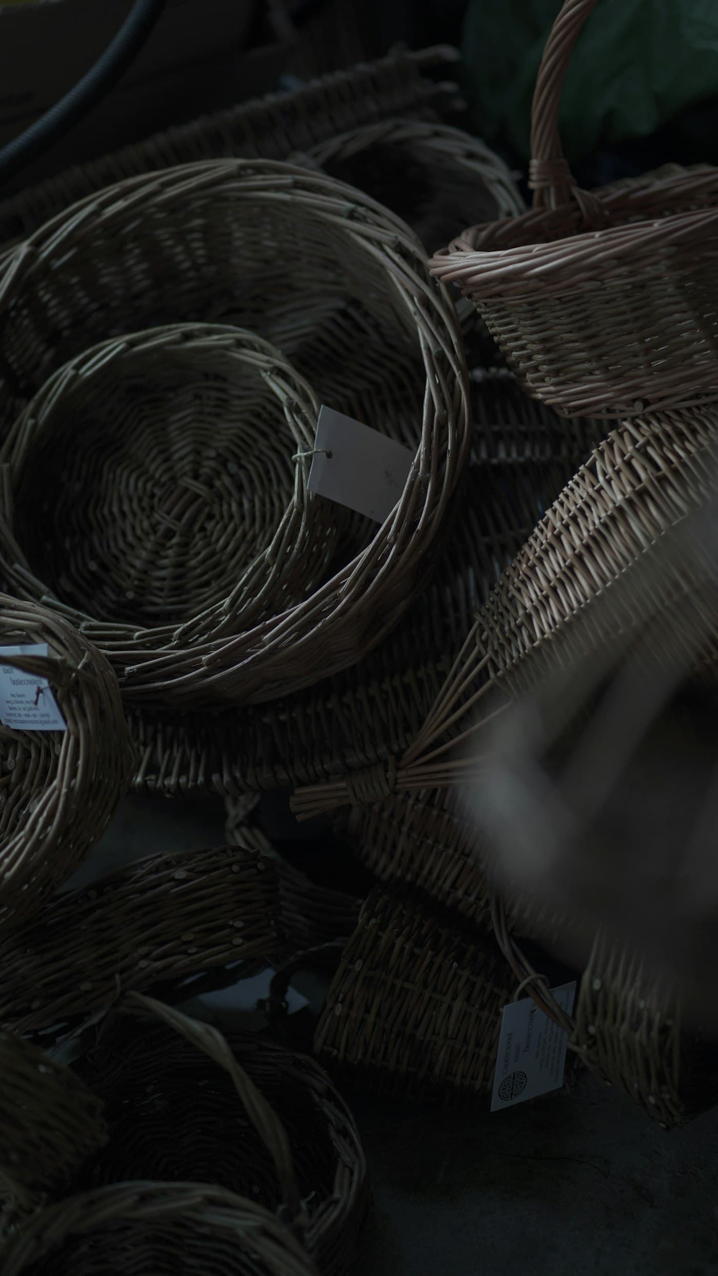 Woven baskets stacked and turned on their sides in a dim storeroom.
