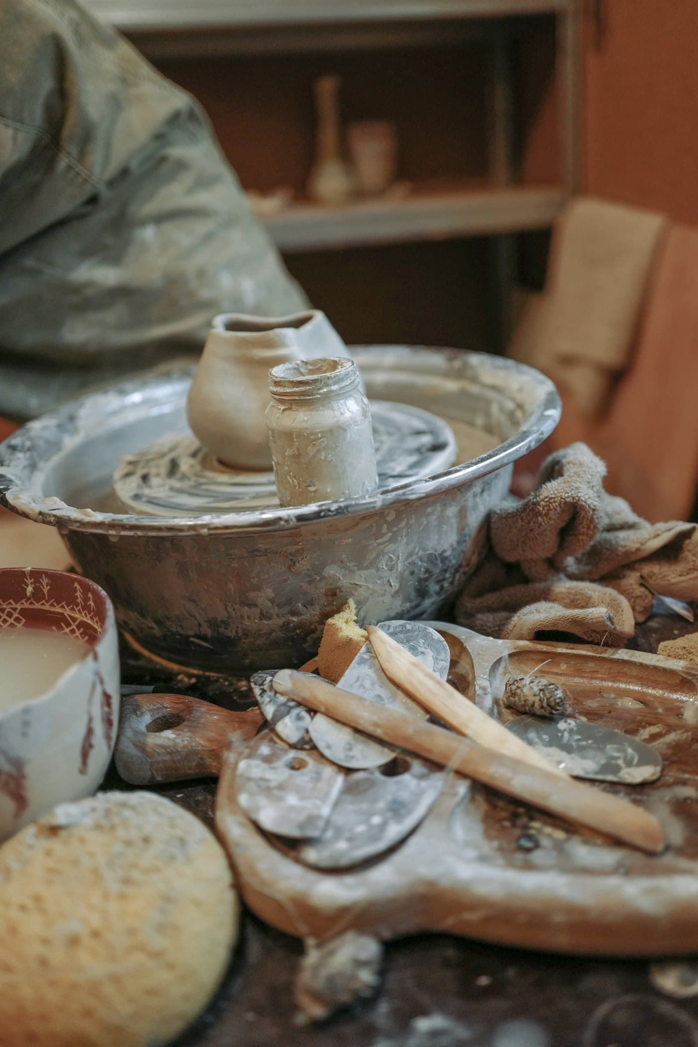 Two small unglazed clay vessels standing on a potter’s wheel head.